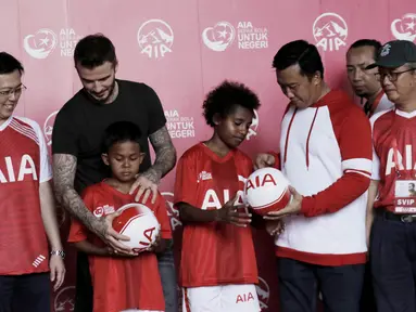 Legenda sepak bola Inggris, David Beckham, dan Menpora RI, Imam Nahrawi, membagikan bola di Stadion Soemantri Brodjonegoro, Jakarta, Minggu (25/3/2018). AIA membagikan 10.000 bola kepada akademi sepak bola di Indonesia. (Bola.com/M Iqbal Ichsan)