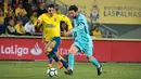 Gelandang Barcelona, Lionel Messi, menggiring bola melewati bek Las Palmas, Ximo Navarro, pada laga La Liga Spanyol di Stadion Gran Canaria, Las Palmas, Kamis (1/3/2018). Kedua klub bermain imbang 1-1. (AFP/Desiree Martin)