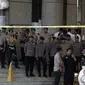 Petugas kepolisian memasang garis polisi di sekitar lokasi Gedung BEI, Jakarta, Senin (15/1). Demi keamanan dan keselamatan, pihak keamanan menutup area sekitar lokasi gedung BEI yang ambruk. (Liputan6.com/Arya Manggala)