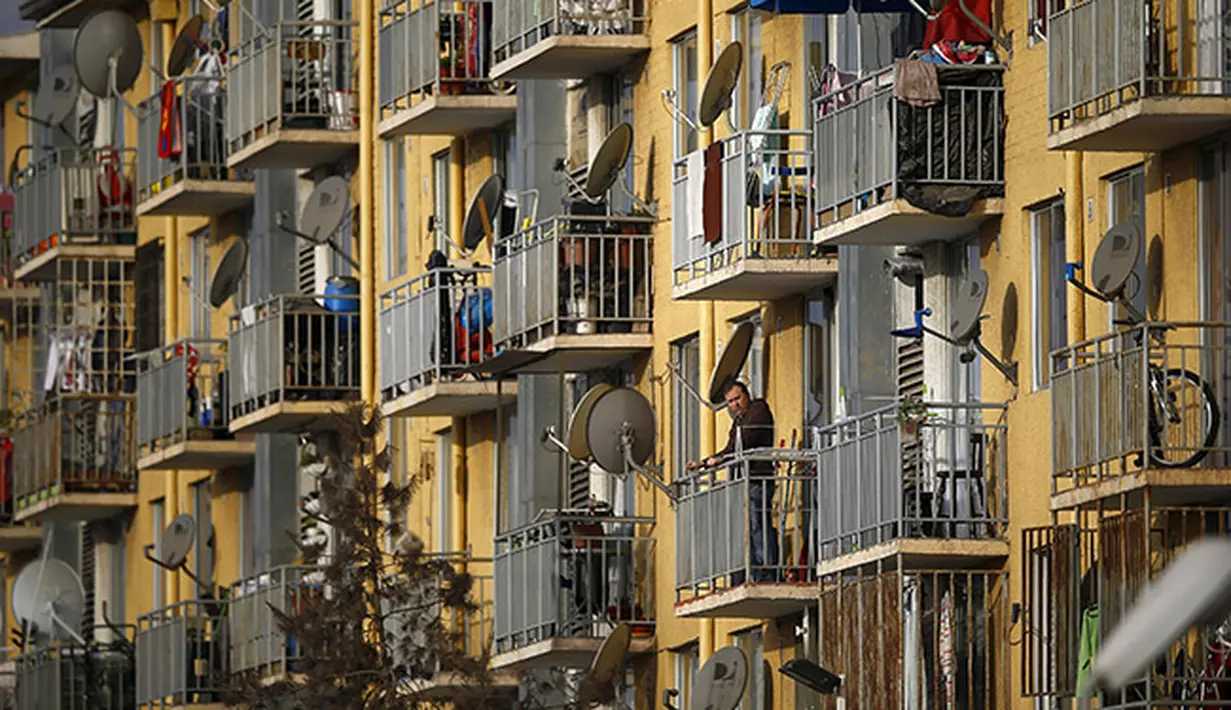 Penghuni rumah susun sederhana di Santiago menyaksikan latihan tim Brasil dari berandanya. (REUTERS/Ricardo Moraes )