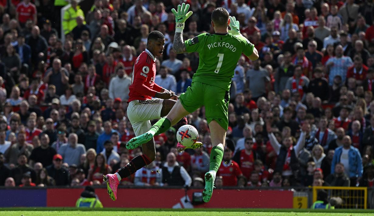 Kiper Everton, Jordan Pickford berusaha menutup ruang tembak striker Manchester United, Marcus Rashford pada laga lanjutan pekan ke-30 Liga Inggris 2022/2023, Sabtu (8/4/2023) di Old Trafford Stadium, Manchester. (AFP/Paul Ellis)