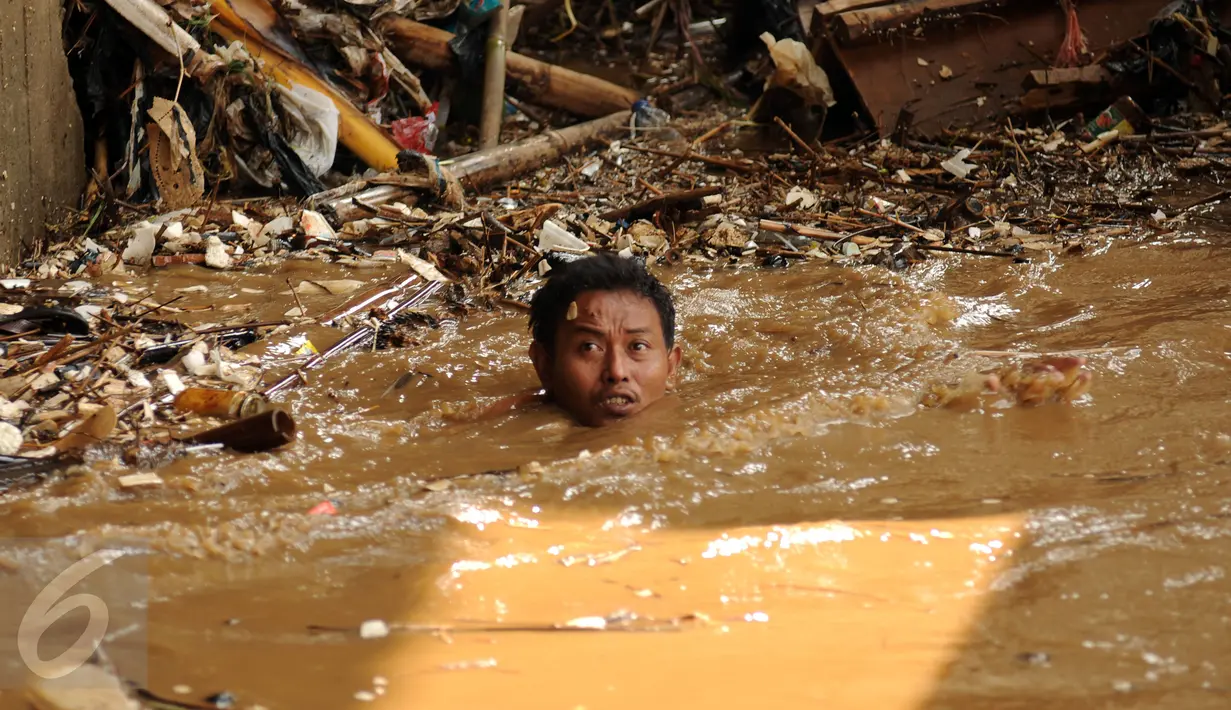 Warga nekat membuka aliran sungai Ciliwung yang terhambat akibat tumpukan sampah di kolong jembatan Rawajati, Kalibata, Jakarta, Senin (16/11/2015). Sampah yang didominasi batang bambu akibat hujan deras, Minggu (15/11). (Liputan6.com/Helmi Fithriansyah)