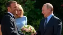 Presiden Prancis Emmanuel Macron (kiri) dan istrinya Brigitte menyambut Presiden Rusia Vladimir Putin di Benteng Bregancon, Bormes-les-Mimosas, Prancis, Senin (19/8/2019). Macron dan Putin membahas di antaranya krisis Ukraina, Iran, dan Suriah. (Alexei Druzhinin, Sputnik, Kremlin Pool Photo via AP)