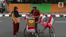 Tarjono (52) melayani pembeli jagung manis di kawasan Cilandak, Jakarta, Kamis (13/8/2020). Tarjono memodifikasi sepeda yang dipakainya untuk berjualan dengan atribut kemerdekaan dalam rangka memperingati HUT ke-75 RI, serta mengajak warga memasang bendera di rumah. (Liputan6.com/Herman Zakharia)