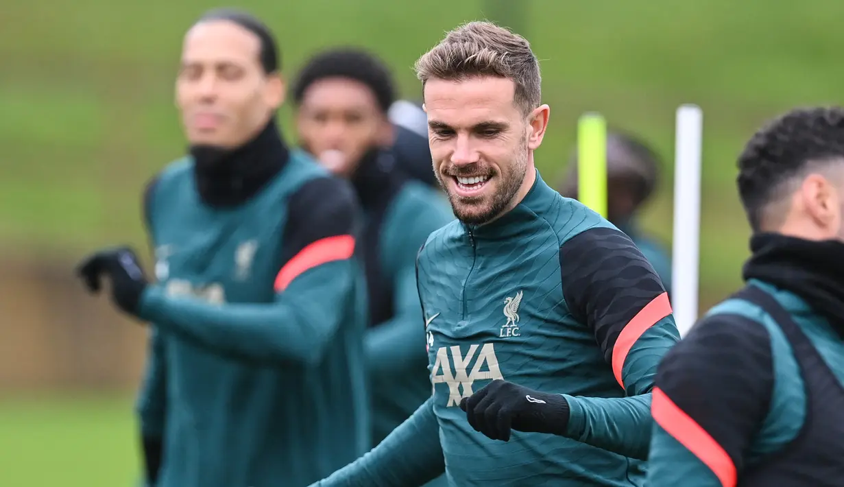 Gelandang Liverpool, Jordan Henderson bersama rekan setimnya melakukan pemanasan dalam sesi latihan di tempat latihan Liverpool FC di Liverpool, Inggris (4/4/2022). Liverpool akan bertanding melawan Benfica pada leg pertama perempat final Liga Champions di Estadio Da Luz, Portugal. (AFP/Paul Ellis)