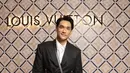 Afgan tampil mengenakan blazer hitam dengan belt tali, serasi dengan celananya. Dipadukan inner kemeja putih yang cocok dengan sneakersnya. Serta membawa shoulder bag box Louis Vuitton. [Instagram/@afgan__]