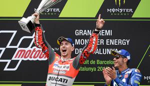 Pembalap Spanyol dari tim Ducati, Jorge Lorenzo merayakan selebrasi didampingi pembalap Italia dari Movistar Yamaha, Valentino Rossi usai balapan MotoGP Catalunya di Sirkuit Catalunya di Montmelo, (17/6). (AFP PHOTO / Lluis Gen)