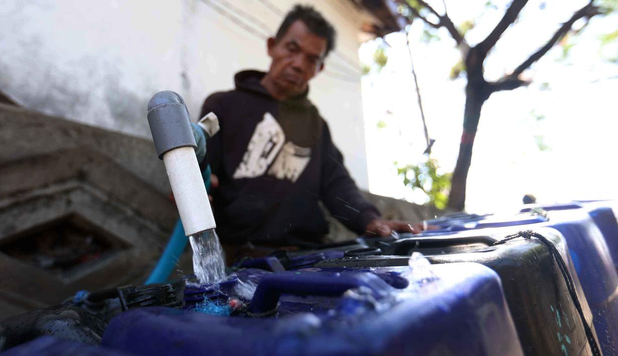 Pedagang mengisi jeriken dengan air bersih untuk segera didistribusikan kepada pelanggan di Kawasan Muara Angke, Jakarta, Kamis (28/5/2026). (Kapanlagi.com/Budy Santoso)