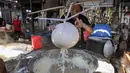 Para perajin berharap pemerintah dapat mengambil langkah untuk menjaga stabilitas harga kedelai agar keberlangsungan usaha kecil tetap terjaga di tengah fluktuasi harga bahan baku. Tampak dalam foto, seorang pekerja menyaring kedelai giling yang sudah dimasak untuk mendapatkan ekstraknya di sebuah pabrik tahu, Surabaya, Jawa Timur pada Kamis 5 Februari 2026. (JUNI KRISWANTO/AFP)