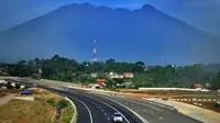 Kendaraan melintasi tol dengan latar belakang Gunung Salak menuju arah Ciawi di kawasan Ciawi Bogor (20/6). Mulai kemarin tol fungsional Bocimi seksi 1 Ciawi-Cigombong diberlakukan satu arah menuju Ciawi. (Merdeka.com/ Arie Basuki)
