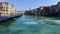 Pandangan umum menunjukkan perairan yang lebih jernih Grand Canal di dekat Jembatan Rialto di Venesia pada 18 Maret 2020, . Sejak Italia memberlakukan lockdown akibat pandemi virus corona, air di Kanal Venesia yang biasanya keruh dan gelap berubah menjadi jernih. (ANDREA PATTARO / AFP)