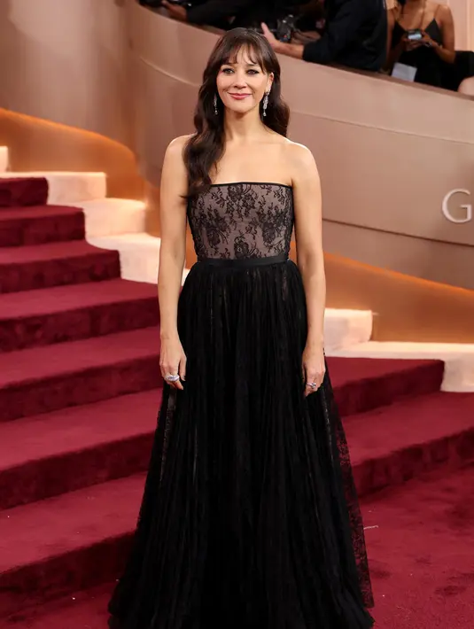 Nuansa klasik-romantis hadir pada Rashida Jones, yang memilih gaun strapless renda hitam. Detail lace transparan mempertegas kesan feminin, disempurnakan riasan Dior Beauty yang lembut. [Dok/DIOR].