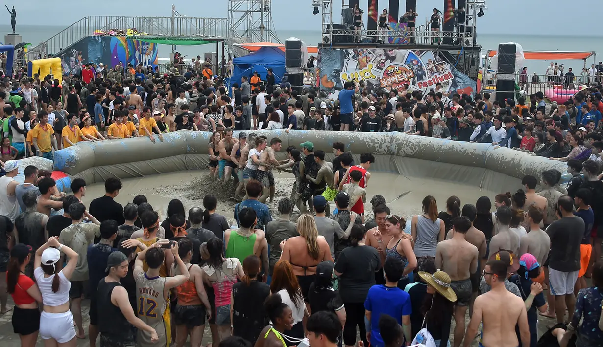 Wisatawan bermain di kolam lumpur selama Boryeong Mud Festival atau Festival Lumpur Boryeong di pantai Daecheon, Korea Selatan, Sabtu (20/7/2019).  Festival yang berlangsung dari 19 - 28 Juli 2019 ini pertama kali diadakan pada 1998 untuk memperkenalkan kosmetik dari lumpur Boryeong. (Minji SUH/AFP)