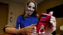 Adriana Macias tersenyum saat bermain ponsel dengan kedua kakinya di Guadalajara, Meksiko, (15/5/2019). Desainer, yang juga seorang pengacara dan aktivis ini mengandalkan kaki untuk melakukan segala aktivitas, termasuk menggambar desain, memasak, hingga mengasuh anak. (AFP Photo/Ulises Ruiz)