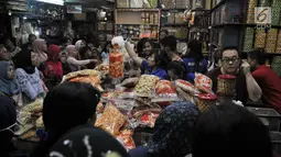 Pedagang melayani pembeli kue kering untuk kebutuhan Lebaran di Pasar Jatinegara, Jakarta, Selasa (5/6). Kue panganan khas Idul Fitri tersebut dibanderol mulai dari Rp 40 ribu hingga Rp 200 ribu per kilogram. (Merdeka.com/ Iqbal S. Nugroho)