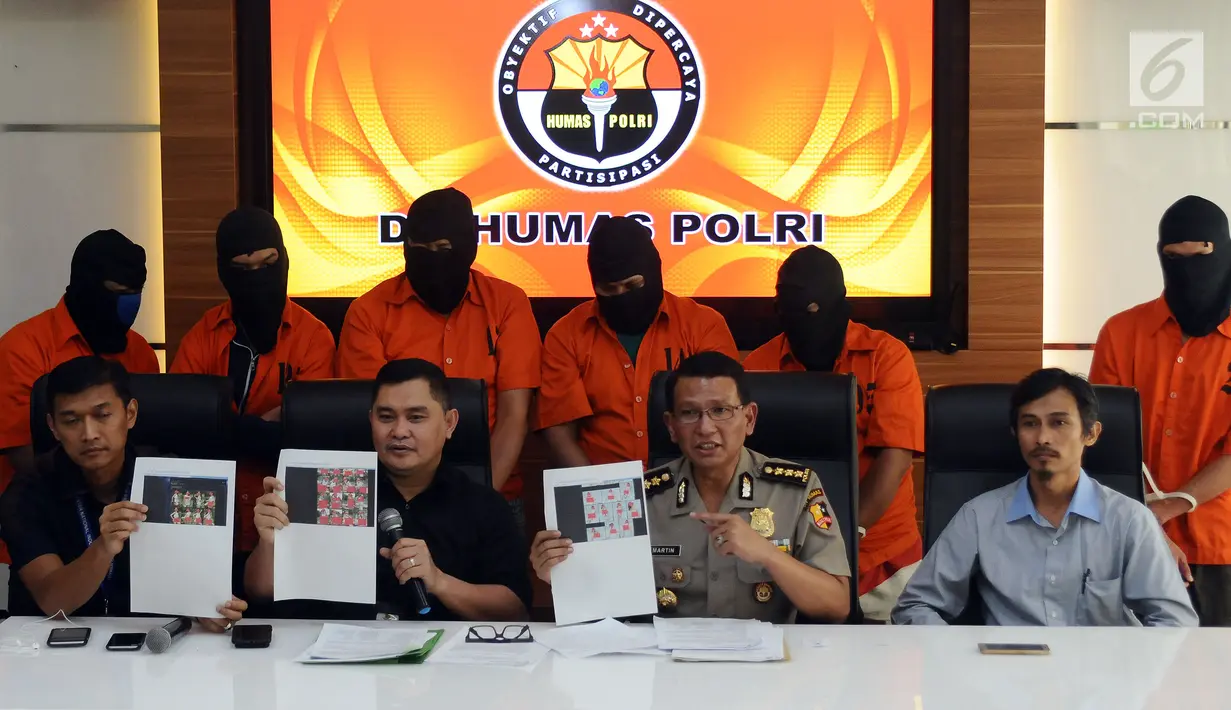 Kabagpenum Humas Mabes Polri, Kombes Martinus Sitompul (ketiga kiri-bawah) menunjukkan barang bukti kejahatan melalui internet di Jakarta, Selasa (30/5). Petugas menahan enam tersangka dari empat kasus berbeda. (Liputan6.com/Helmi Fithriansyah)