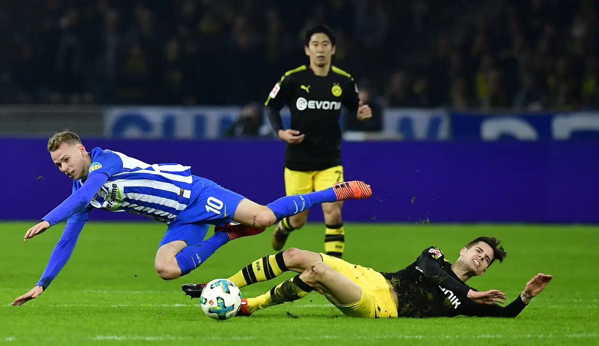 Pemain Borussia Dortmund, Julian Weigl dan pemain Hertha Berlin Ondrej Duda terjatuh saat berebut bola pada lanjutan Bundesliga di Olympiastadion Berlin, Sabtu (20/1). Hasil imbang 1-1 mengakhiri duel antara Hertha Berlin vs Dortmund. (Tobias SCHWARZ/AFP)