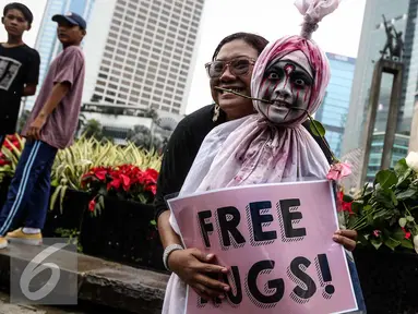 Pengunjung CFD memeluk bocah berdandan hantu saat CFD di Bundaran HI, Jakarta (13/11). Kegiatan "Share For Love" ini dalam rangka meredakan ketegangan di masyarakat pasca aksi 4/11 lalu. (Liputan6.com/Faizal Fanani)