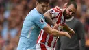 Bek Manchester City, John Stones berusaha merebut bola yang dibawa penyerang Stoke City, Jese saat bertanding pada lanjutan Liga Inggris di Etihad Stadium, Manchester, (14/10). City menang 7-2 atas Stoke. (AFP Photo/Oli Scarff)
