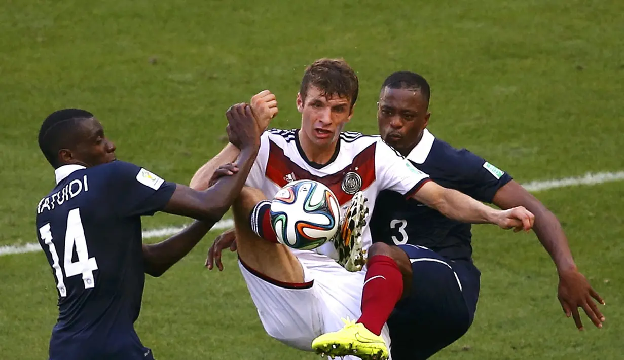 Dua pemain Timnas Perancis, Blaise Matuidi (kiri) dan Patrice Evra, berusaha merebut bola dari penyerang Jerman, Thomas Mueller, saat berlaga di perempat final Piala Dunia 2014 di Stadion Maracana, Rio de Janeiro, (4/7/2014). (REUTERS/Ricardo Moraes)