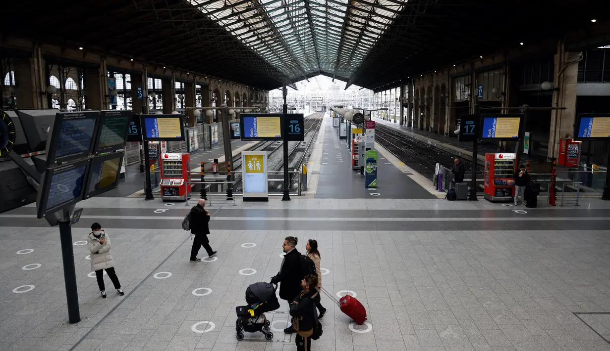 Sejumlah pelancong berjalan melewati layar informasi saat lalu lintas terganggu di stasiun kereta Gare du Nord pada hari kedua pemogokan nasional dan protes terhadap rencana reformasi pensiun pemerintah di Paris, Selasa (31/1/2023). Operator transportasi ibu kota RATP mengatakan sebagian besar layanan kereta bawah tanah dan metro Paris akan sangat dibatasi. (Ludovic MARIN/AFP)