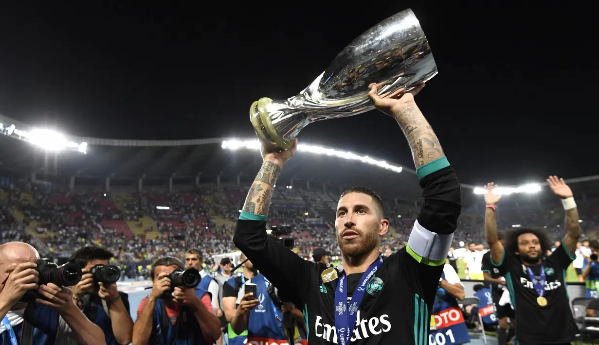 Kapten Real Madrid, Sergio Ramos, mengangkat trofi Piala Super Eropa usai mengalahkan Manchester United di Stadion Philip II, Skopje, Selasa (8/8/2017). Ini merupakan gelar Piala Super Eropa keempat bagi Real Madrid. (AFP/Dimitar Dilkoff)