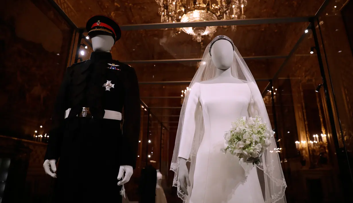 Gaun pernikahan Meghan Markle dan Pangeran Harry ditampilkan pada pameran A Royal Wedding di Kastil Windsor, London, 25 Oktober 2018. Gaun yang dikenakan Meghan, dipajang di kotak kaca besar di samping kostum pernikahan Pangeran Harry. (AP/Matt Dunham)