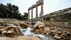 Air mengalir melalui reruntuhan di lokasi kota kuno Cyrene (Shahhat) Yunani-Romawi di Libya timur, sekitar 60(37 mil) barat Derna setelah banjir dahsyat, pada 21 September 2023. (Ozan KOSE / AFP)
