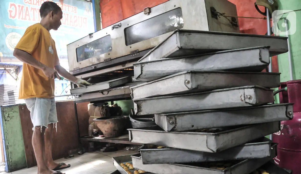 Pekerja memasukkan kue kering ke dalam oven di industri rumahan Pusaka Kwitang, Jakarta, Kamis (6/4/2023). (merdeka.com/Iqbal S Nugroho)