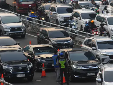 Petugas Jasa Marga melakukan pelayanan transaksi  kartu masuk tol dalam kota kepada pengendara roda empat di Jakarta, Selasa (9/5/2023). (merdeka.com/Imam Buhori)