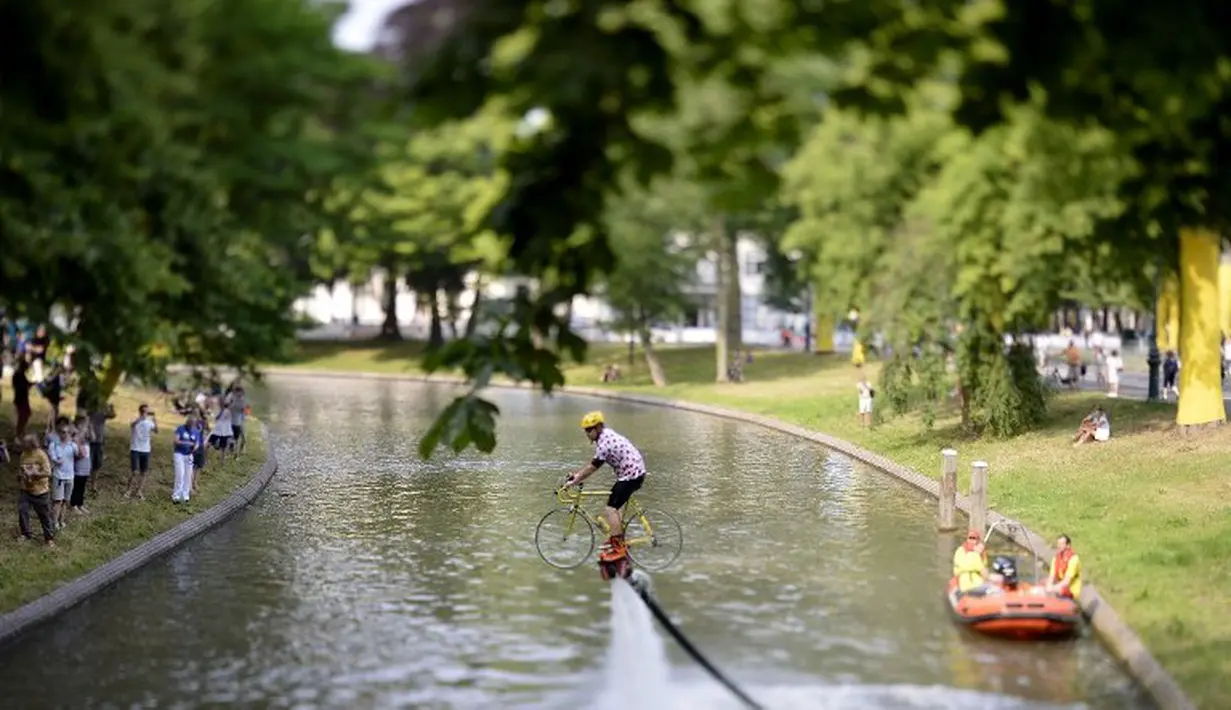 Seorang pria beraksi dengan menggunakan flyboard sepeda di sebuah kanal untuk menyambut lomba balap sepeda Tour de France di Taman Lepelenburg, Utrecht, Belanda. (2/7/2015). (AFP PHOTO/Jeff Pachoud)