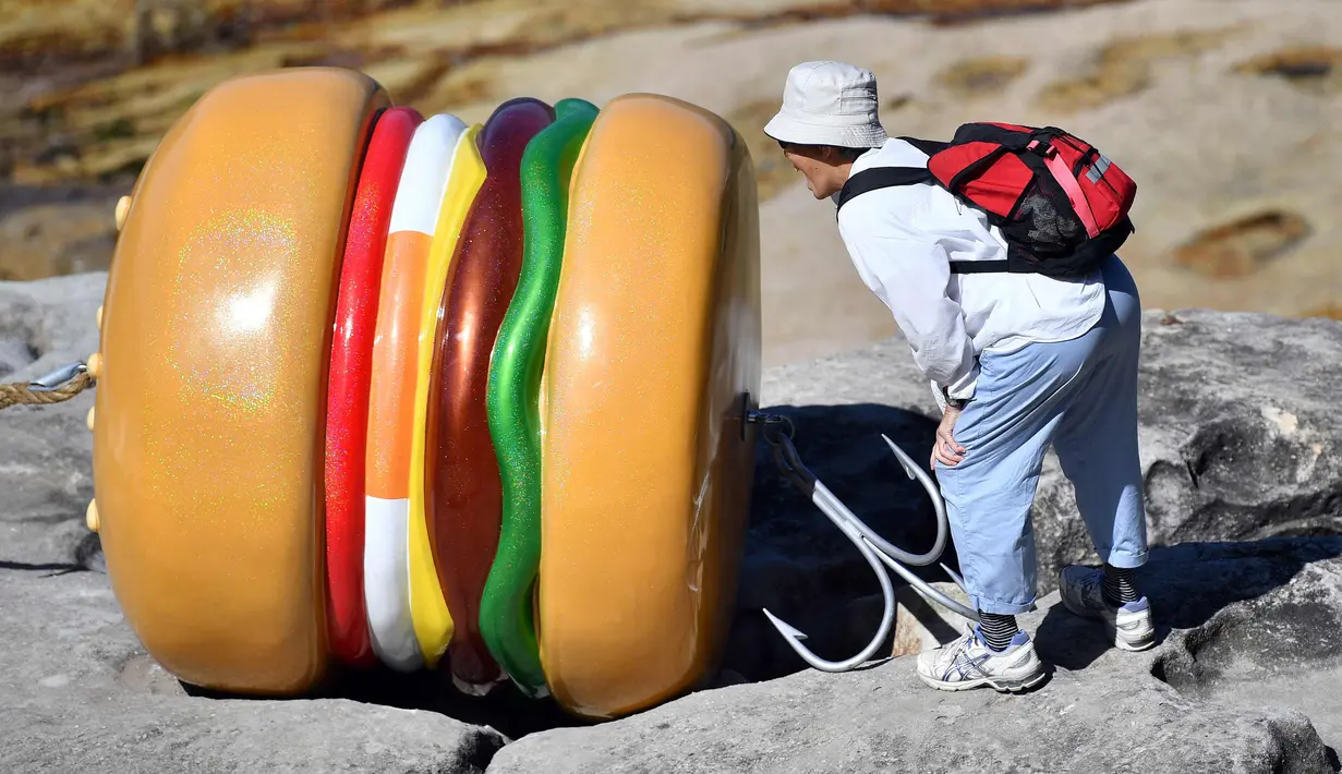 Pengunjung melihat patung seniman James Dive selama pameran "Sculpture by the Sea" di dekat pantai Bondi di Sydney (19/10). Pameran  dimulai di sepanjang pantai Bondi menuju pantai Tamarama dan berlangsung hingga 5 November 2017. (AFP Photo/Saeed Khan)