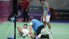 Dokter memeriksa ganda putra Indonesia Yeremia Rambitan yang cedera di dekat rekannya, Pramudya Kusumawardana saat melawan pasangan Malaysia Aaron Chia/Soh Wooi Yik pada perempat final Indonesia Open 2022 di Istora Senayan, Jakarta, Jumat (17/6/2022). Pram/Yere secara dramatis dikalahkan pasangan Malaysia Aaron Chia/Soh Wooi Yik 21-14, 12-21, 20-22. (AP Photo/Dita Alangkara)