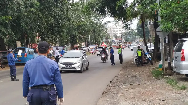 Petugas check point di Bekasi berjaga menggunakan standarisasi PSBB. Foto: Liputan6.com/Bam Sinulingga