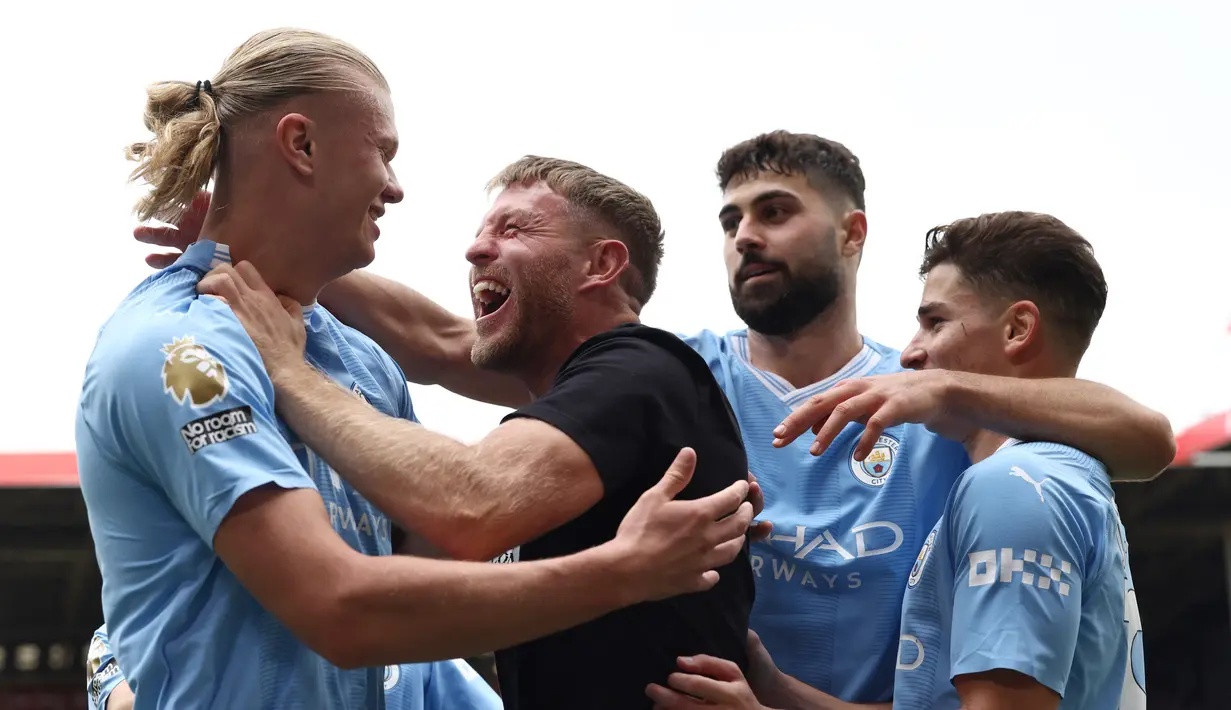 Ternyata pria yang memeluk Haaland adalah Terry Flanagan. Dia merupakan mantan juara dunia kelas ringan asal Inggris yang pensiun pada 2019. (Photo by Darren Staples / AFP)