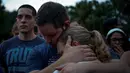 Dua orang berpelukan dalam peringatan untuk korban penembakan di Pulse, klub malam khusus kaum gay di Orlando, Florida, AS, Minggu (12/6). 50 orang tewas dan 53 terluka akibat penembakan yang dilakukan Omar Saddiqui Mateen. (REUTERS/Adrees Latif)