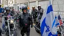 Anggota geng motor Israel Samson Riders beristirahat sebelum menuju Kedutaan Besar AS yang baru di Yerusalem saat melakukan konvoi dari Tel Aviv, (13/5). Mereka memasang bendera AS dan Israel di motoR. (AFP Photo/Jack Guez)