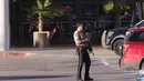 Polisi bersenjata berjaga di luar Rolling Oaks Mall, San Antonio, Texas, setelah terjadinya baku tembak, Minggu (22/1). Satu dari dua pengunjung yang mencoba menggagalkan aksi perampokan toko perhiasan, tewas ditembak pelaku perampokan. (AP Photo)