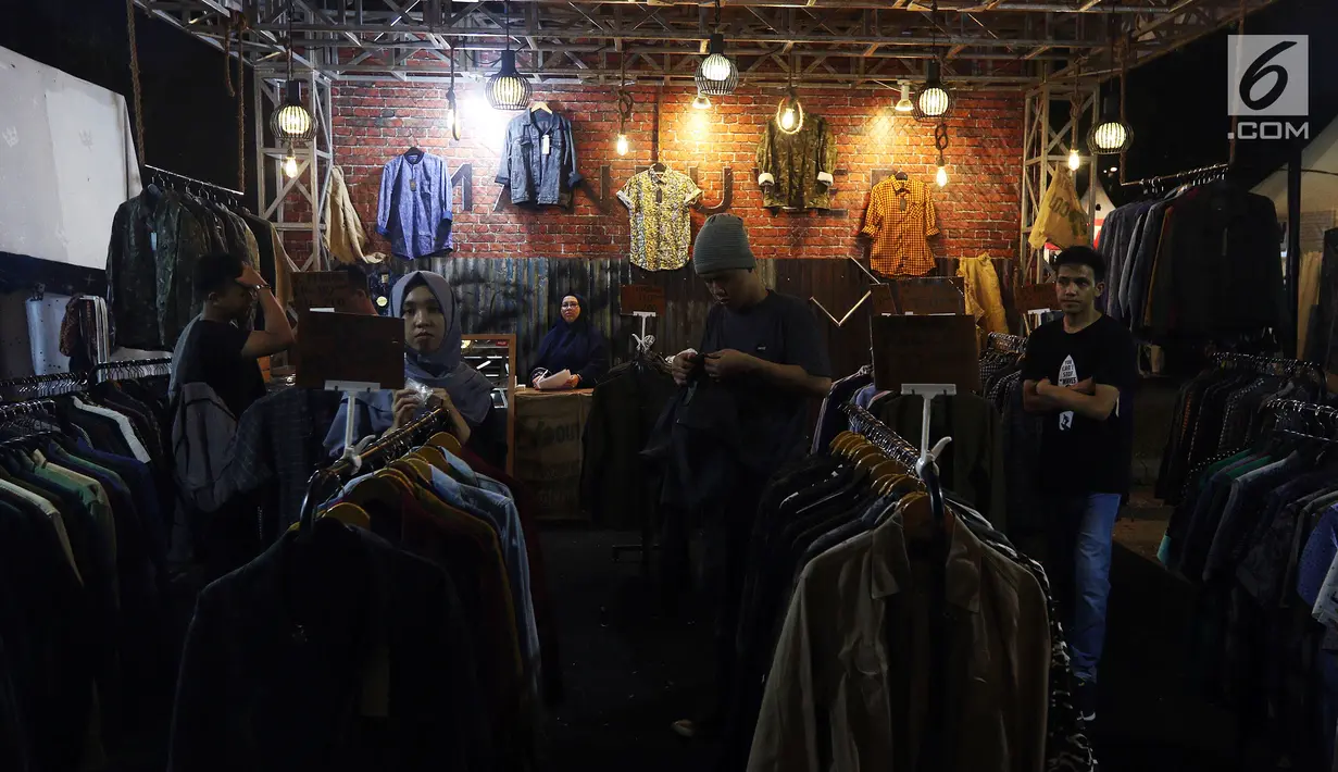 Pengunjung melihat-lihat produk merek pakaian di Jakcloth Indonesian Pride 2018, Jakarta, Rabu (19/12). Potongan harga hingga produk gratis diberikan kepada pengunjung Jakcloth Indonesian Pride 2018. (Liputan6.com/JohanTallo)
