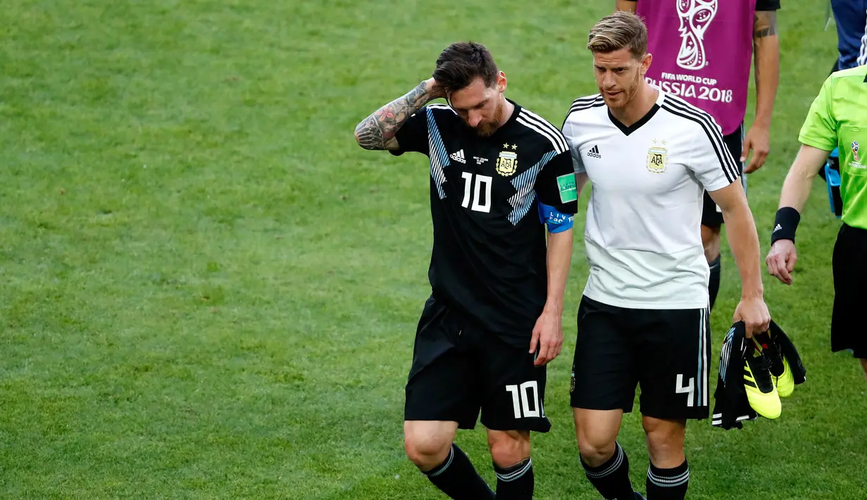 Pemain Argentina, Lionel Messi (kiri) meninggalkan lapangan dengan rekan setimnya Cristian Ansaldi usai pertandingan Grup D Piala Dunia 2018 antara Argentina dan Islandia di Stadion Spartak, Moskow, Rusia, Sabtu (16/6). (AP Photo/Rebecca Blackwell)