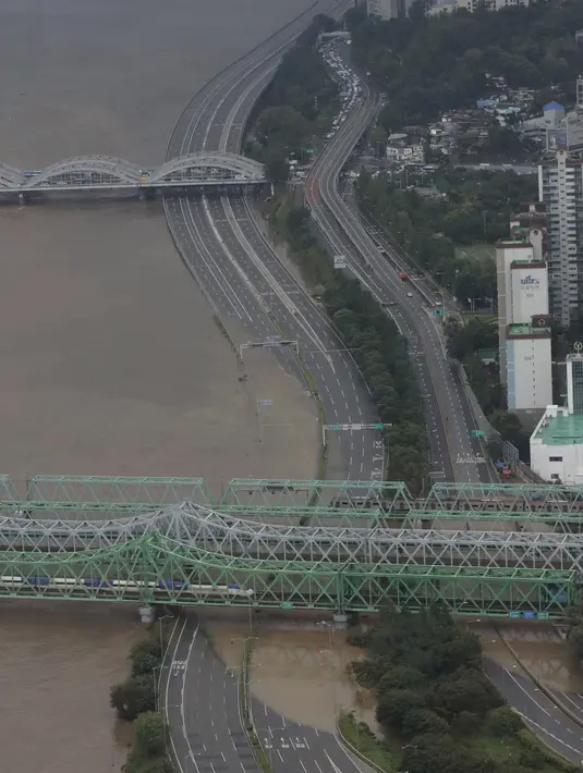 Sebagian jalan utama dekat Sungai Han terendam banjir akibat hujan lebat di Seoul, Korea Selatan, Kamis (6/8/2020). Hujan lebat terus mengguyur Korea Selatan, mendorong pihak berwenang untuk menutup sebagian jalan raya dan mengeluarkan peringatan banjir. (AP Photo/Lee Jin-man)