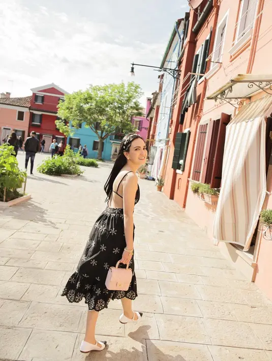 Liburan di Italia, Shandy Aulia tampil menawan kenakan v neck dress berwarna hitam dengan aksen bordiran cantik. [Instagram/shandyaulia]
