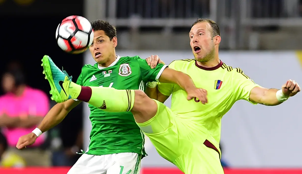 Pemain Venezuela, Jose Velazquez (kanan), berebut bola dengan pemain Meksiko, Javier Hernandez, dalam laga Grup C Copa America 2016 di Stadion NRG, Houston, AS, Selasa (14/6/2016) WIB. (AFP/Alfredo Estrella)