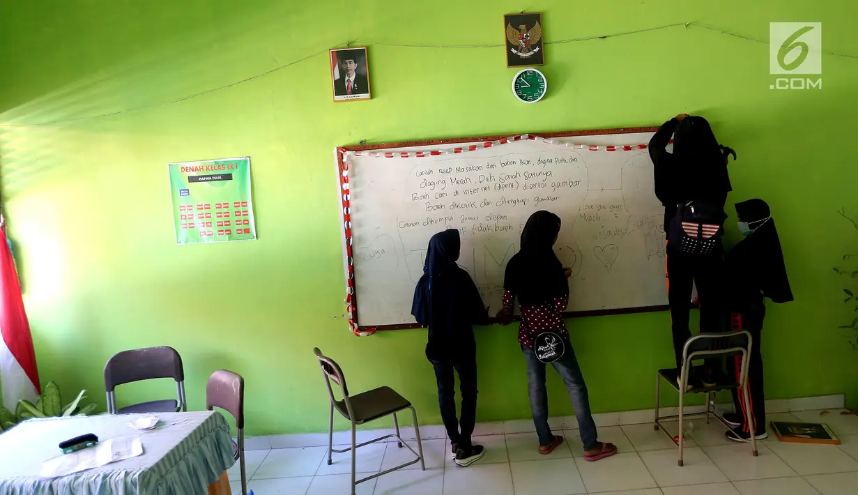 Sejumlah siswi memasang papan tulis yang jatuh akibat gempa di dalam kelas SMP Negeri 6 Palu, Sulawesi Tengah, Senin (8/10). Pascagempa dan tsunami Palu, pihak sekolah melakukan pendataan untuk mengetahui jumlah siswa sekolah. (Liputan6.com/Fery Pradolo)