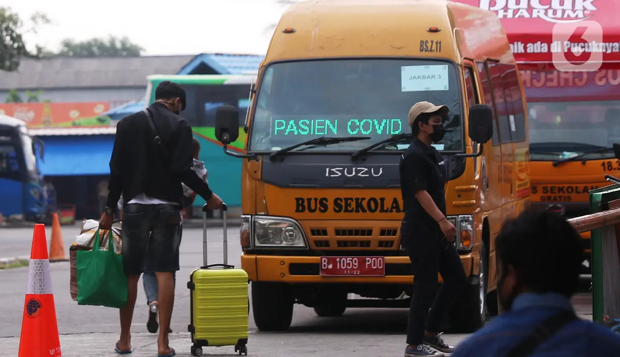 Sebuah bus sekolah disiagakan di Terminal bus Kalideres, Jakarta Barat, Senin (17/5/2021). Bus sekolah tersebut untuk membawa penumpang yang positif Covid-19 menuju Puskesmas Kalideres guna menjalani tes polymerase chain reaction (PCR). (Liputan6.com/Angga Yuniar)