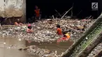 Pasukan Orange mengangkat sampah yang terbawa arus sungai di Pintu air Manggarai, Jakarta, Senin (2/10). Pembersihan itu dilakukan untuk melancarkan aliran Sungai Ciliwung yang melewati Pintu Air Manggarai (Liputan6.com/Johan Tallo)