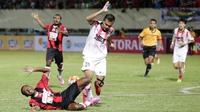 Pemain Persipura, Yustinus Pae, dijatuhkan pemain Persija, Rezaldi Hehanusa, pada laga Torabika Soccer Championship 2016 di Stadion Mandala, Jayapura, Jumat (29/4/2016). (Bola.com/Nicklas Hanoatubun)