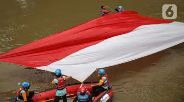 Sejumlah relawan membentangkan bendera Merah Putih di aliran kali
Ciliwung di kawasan Sudirman, Jakarta, Minggu (22/8/2021). Pembentangan atau pengibaran bendera Merah Putih tersebut dilaksanakan untuk memperingati HUT ke-76 RI. (Liputan6.com/Faizal Fanani)