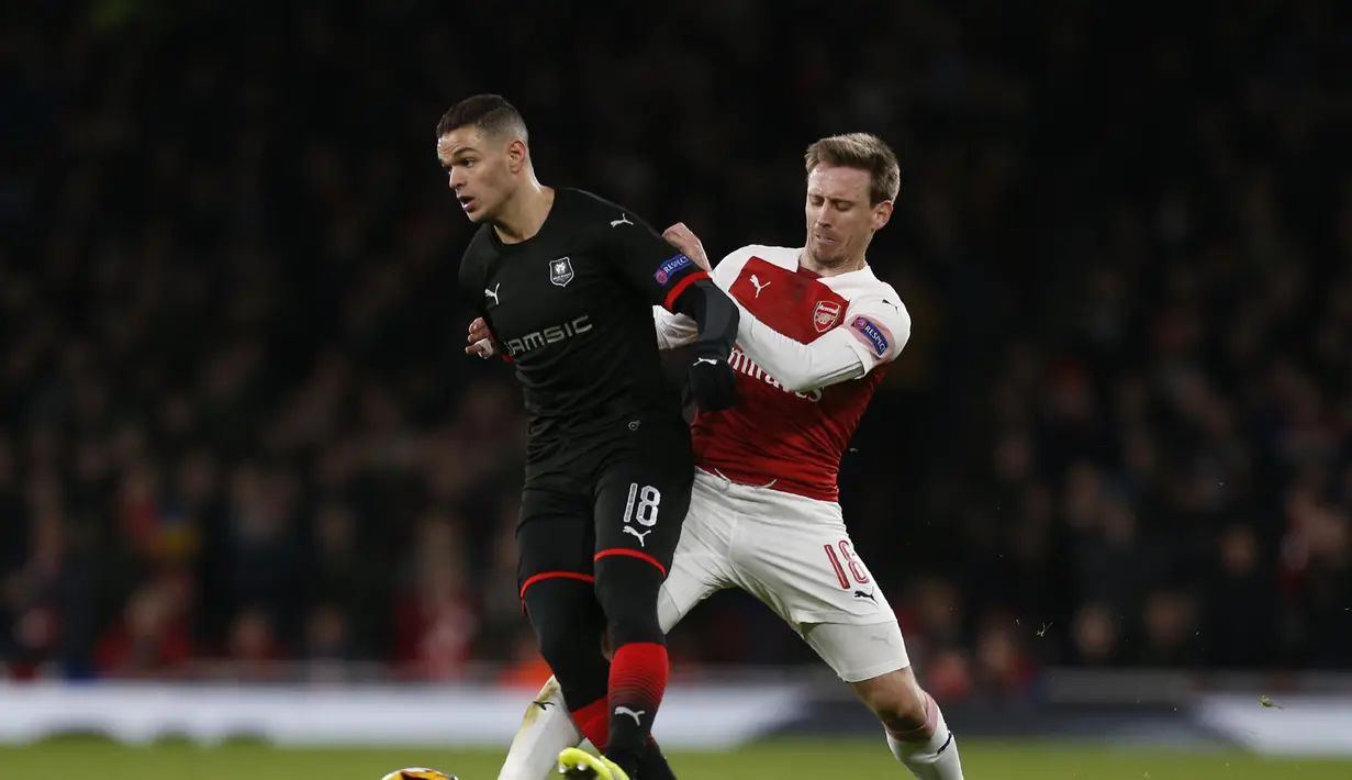 Bek Arsenal, Nacho Monreal mencoba menghentikan Hatem Ben Arfa pada leg kedua,babak 16 besar Liga Europa yang berlangsung di Stadion Emirates, London, Jumat (15/3). Arsenal menang 3-0 atas Rennes. (AFP/Ian Kington)