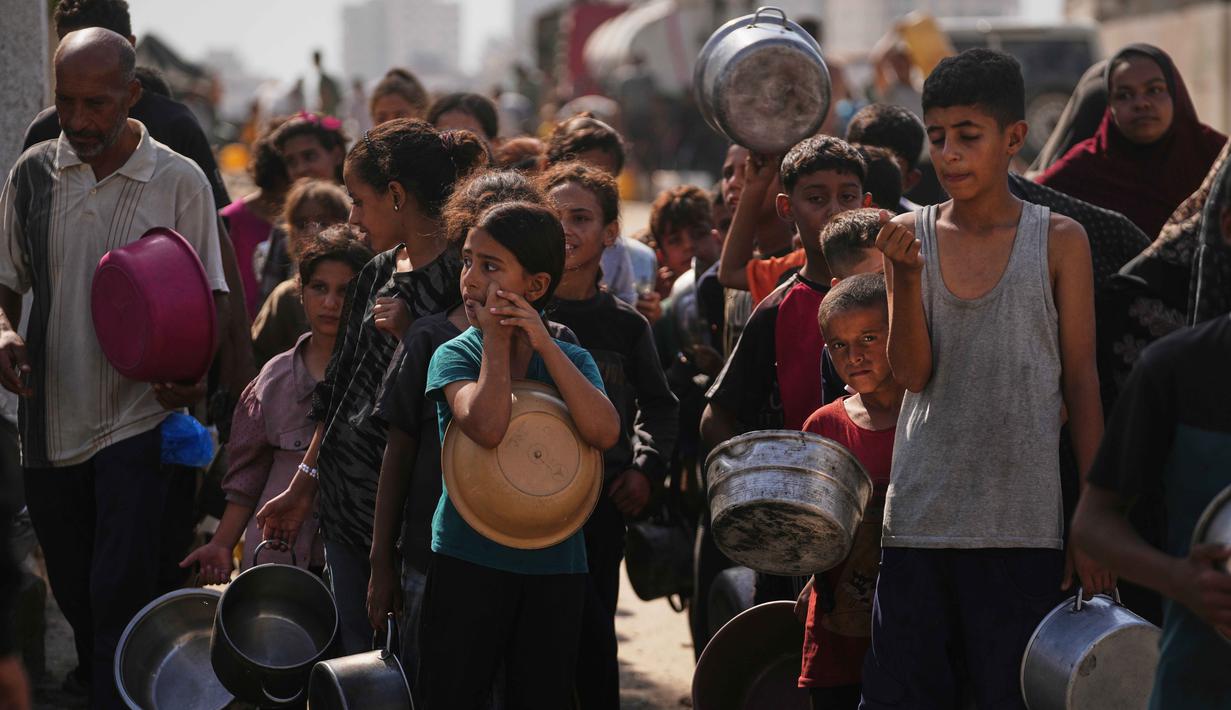 Warga Palestina menunggu untuk menerima makanan di dapur komunitas di Kota Gaza, Kamis 23 Oktober 2025. (AP Photo/Abdel Kareem Hana)